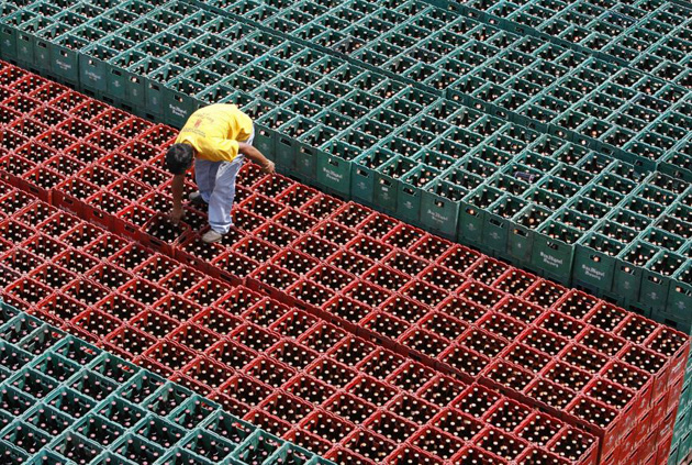 A worker arranges crates of beer before loading them onto a truck inside a San Miguel Beer warehouse in Manila