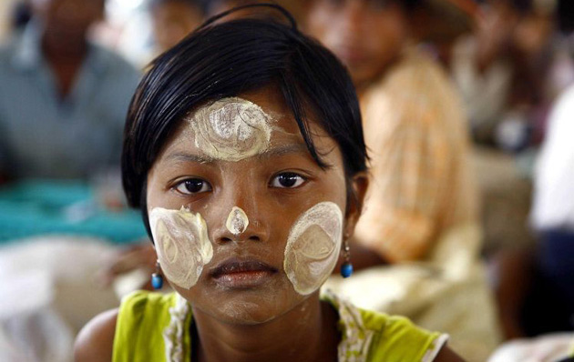survivor sit at a temple turned into a makeshift refugee center in the town of Labutta