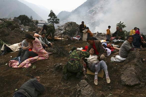 Survivors sit amongst the rubble