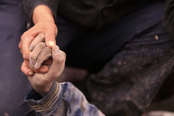 A relative holds a victims hand