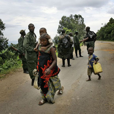 A woman and children seek refuge near the UN base in the village of Kiwanja