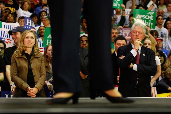 Bill Clinton watches Hillary Clinton on stage