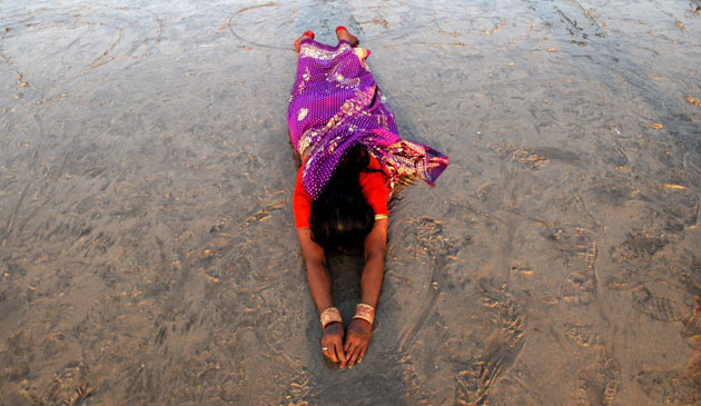 A Hindu devotee worships the setting Sun while celebrating Chhat Pooja    
