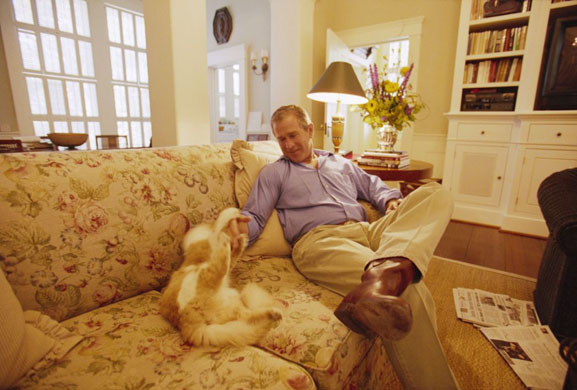 2000: George Bush teases his cat Ernie while at the Governor's Mansion in Austin, Texas