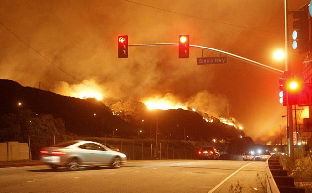 Flames burn on both sides of Interstate 5 during a wind-driven wildfire in the Sylmar section of Los Angeles