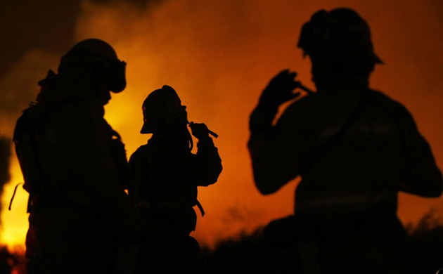 Firefighters gear up as a wildfire approaches Carbon Canyon road near Brea, California