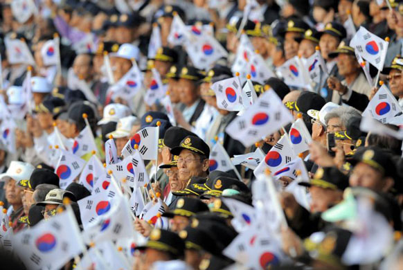 Seoul, South Korea: Veterans wave national flags during a ceremony marking the country's Armed Forces Day