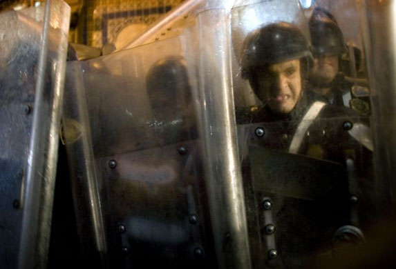 Mexico City, Mexico: Riot police take cover during clashes with demonstrators that erupted at a march to mark the 1968 Tlatelolco plaza 'massacre'
