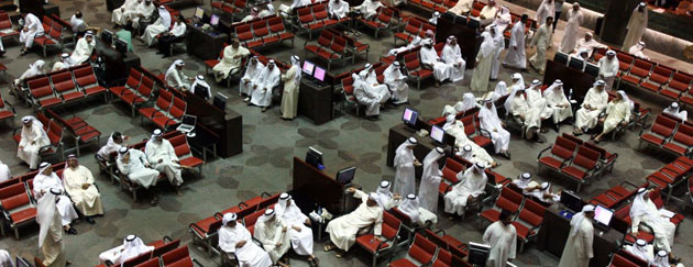 Kuwait City, Kuwait: Traders follow the market's movement at the Stock Exchange