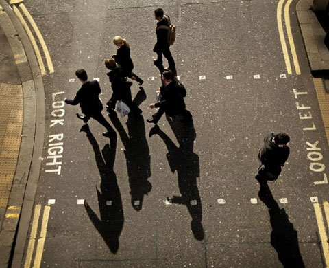 London, UK: City workers cross a road