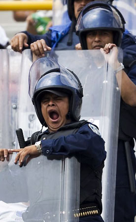 Mexico City, Mexico: A police officer yawns during a Mexican Soccer League match between Pumas and Cruz Azul