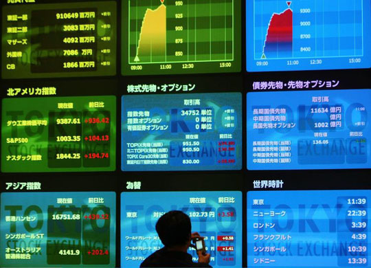 Tokyo, Jaoan: A visitor takes pictures of an board displaying the Nikkei Index and other figures at Tokyo Stock Exchange