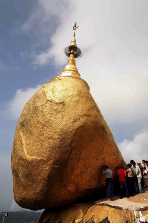 Mon State, Myanmar: People apply gold leaf to the Kyait-Hti-Yo pagoda