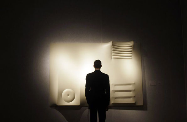 London, UK: A Christie's employee poses for photographs in front of a untitled piece by Agostino Bonalumi