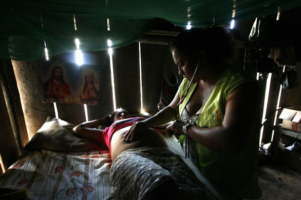 Kapawi, Ecuador: A doctor performs checks on a pregnant Ashuar Indian woman during a health campaign
