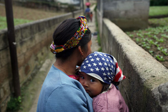 Zunil, Guatemala: A woman carrying her child arrives for the celebrations honouring Maximon, a pagan saint venerated mostly by the Mayan Indian communities