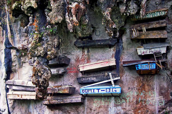 Sagada, Philippines: An age old practice among the Kankanaey tribes. The coffins of their relatives are crafted from century old pine trees and given pagan death rituals