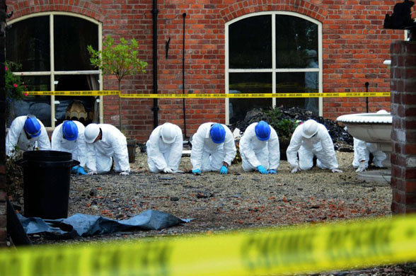 Maesbrook, UK: Forensic officers outside the burnt out family mansion of millionaire businessman Christopher Foster