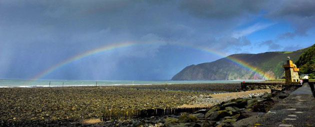 Lynmouth, UK: A rainbow forms during heavy rain