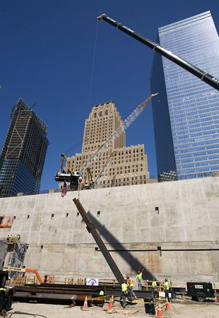 New York, US: Iron workers help guide the first steel column as it is lifted by crane at the National September 11 Memorial & Museum site