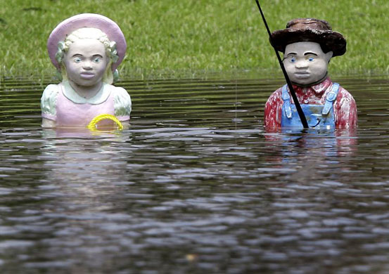 Houma, Louisiana: Two fishing figurines stand in the high waters of a bayou after Hurricane Gustav stormed through the area