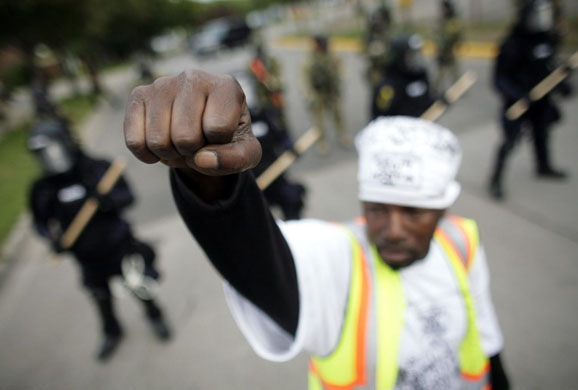 St Paul, Minnesota: A demonstrator raises his fist in front of lines of riot police during a protest outside the 2008 Republican National Convention