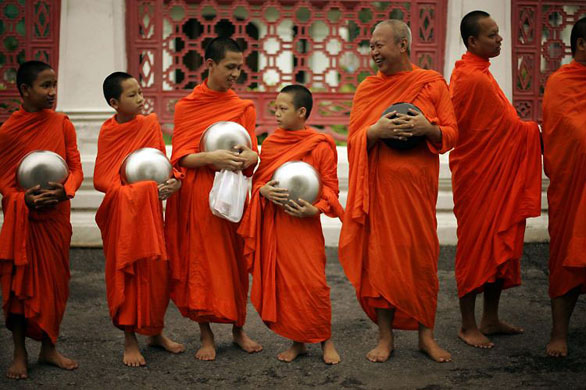 Bangkok, Thailand: Buddhist monks wait for offerings near Government House