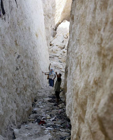 Cairo, Egypt: Residents walk between rocks that fell in Manshiyet Nasser shanty town killing at least 31 people