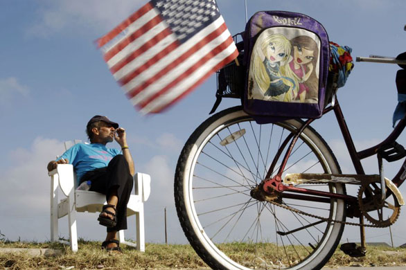 Galveston, US: Randall Dowdell smokes a cigarette as he listens to church service on a radio