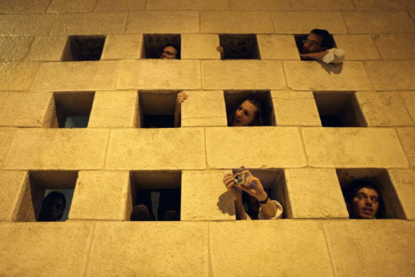 Bystanders survey the scene of an attack where an alleged terrorists ran a car into a group of soldiers