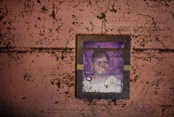 A portrait of a girl hangs on a wall of a home that shows the high water mark after recent flooding in Haiti