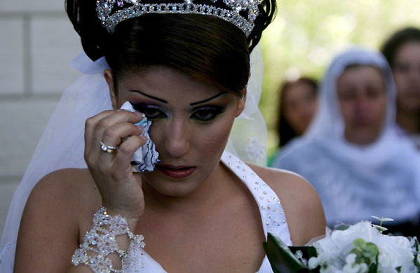 Golan Heights, Israel: Druze bride Arin Safadi cries as she leaves her family before crossing to Syria to marry her cousin Rabiee from Damascus