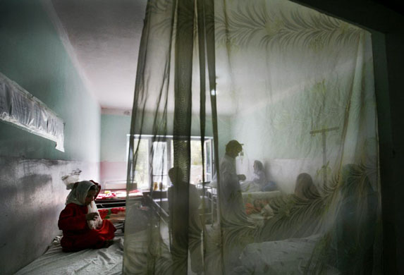 Feyzabad, Afghanistan: A girl adjusts waits for treatment in a local hospital