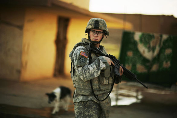 Baghdad, Iraq: US Army Staff Sgt. Deryk Simmons stands guard during a patrol with Iraqi police on the outskirts of Mosul