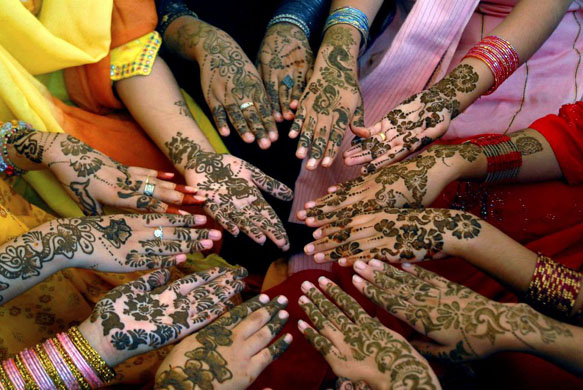Multan, Pakistan: Girls show their hands painted with traditional henna in preparation for the upcoming Eid al-Fitr festival