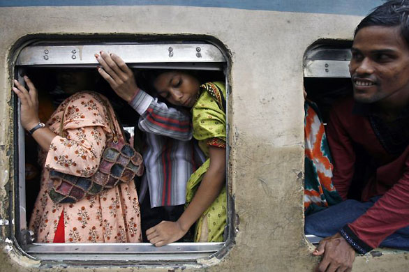 Dhaka, India: Passengers inside the carriage of an overcrowded train bound for the south of the country