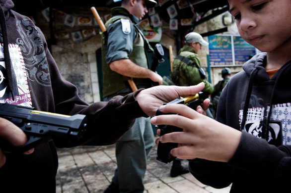 Jerusalem: Israeli border police patrol as Palestinian children play with toy guns received as presents for the Muslim festival of Eid al-Fitr