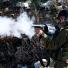 Israeli soldier fires tear gas during clashes with Palestinian protesters