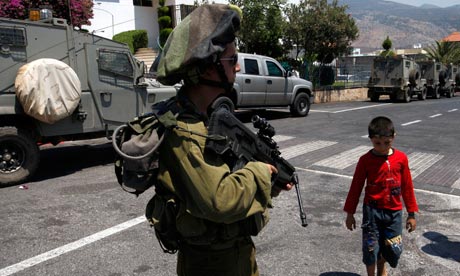 Israeli soldier stands guard in Ghajar on the Israeli-Lebanese border