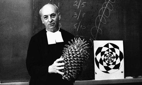 Brother Brousseau uses a large pine cone to demonstrate the Fibonacci principle of mathematics