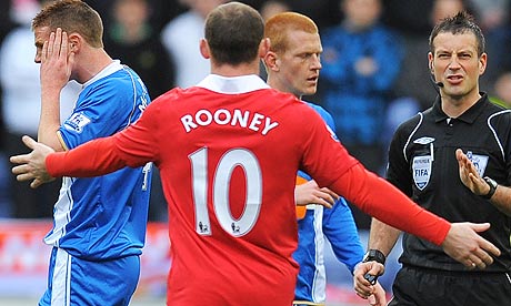 The referee Mark Clattenburg right speaks to Wayne Rooney after he elbowed 