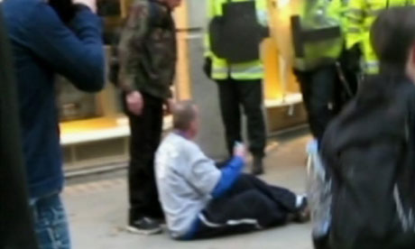 Ian Tomlinson surrounded by police after falling on to ground