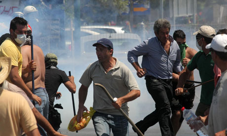 Taxi drivers run from teargas during clashes on the island of Crete, Greece. Photograph -- Image Photo Services - AP
