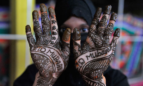 A Muslim woman shows her hands decorated with traditional henna