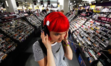 A girl at a listening post inside a record shop