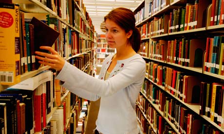 A young woman picking a book from a library