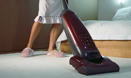A woman vacuuming a bedroom 
