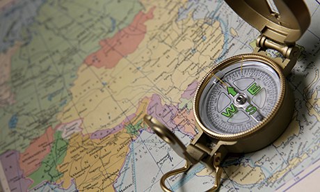 A compass on the world map of the atlas