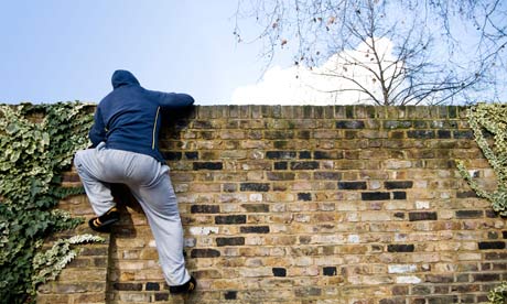 A young man climbing over a wall