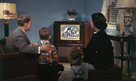A young 1950s family watching television